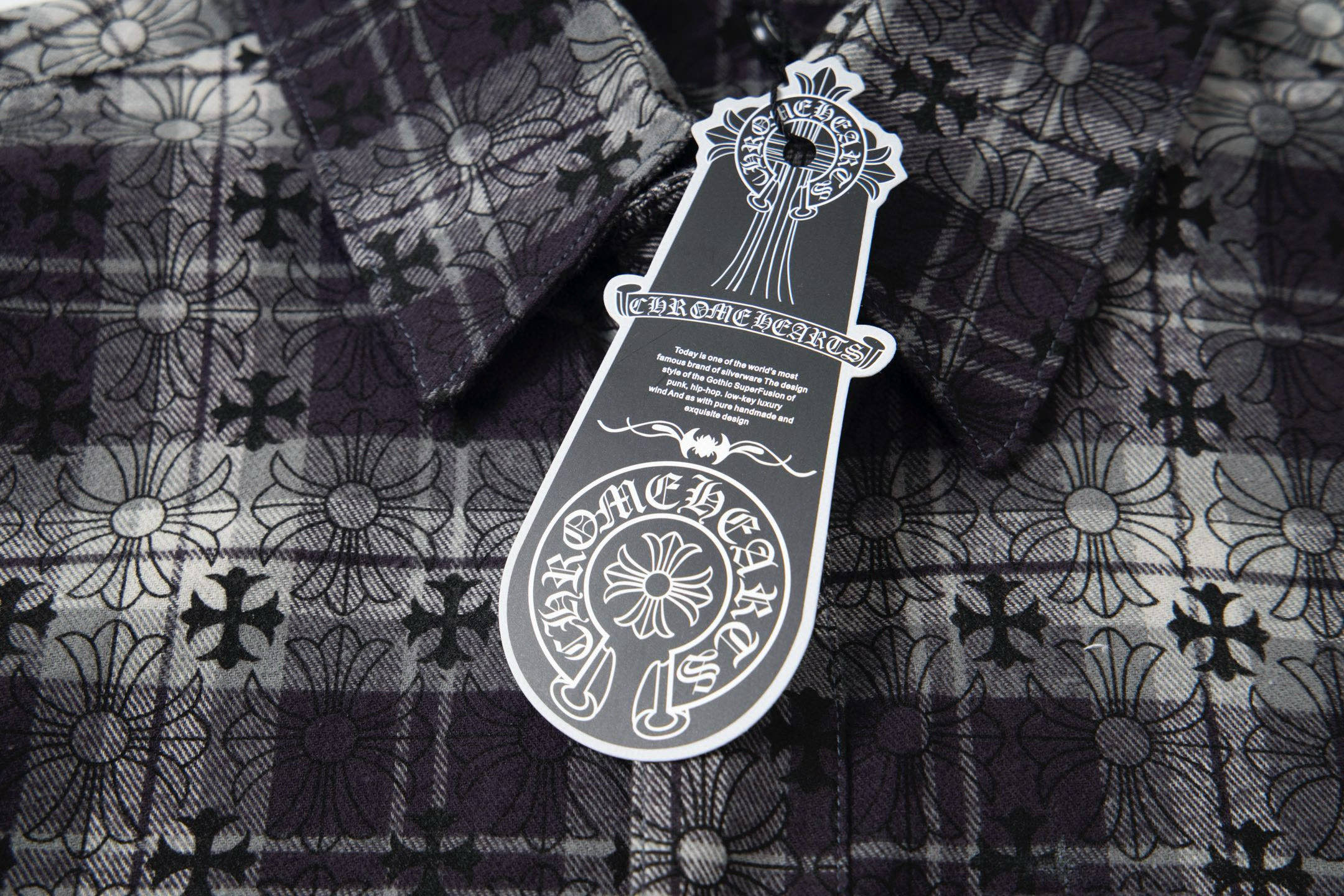Long patterned garment with dark floral print and front tag