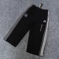 Black track pants with white side stripes, elastic waist, Y-3 logo and graphic print