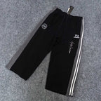 Black track pants with white side stripes, elastic waist, Y-3 logo and graphic print