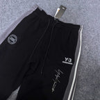 Black track pants with white side stripe, Y-3 logo and signature graphic print