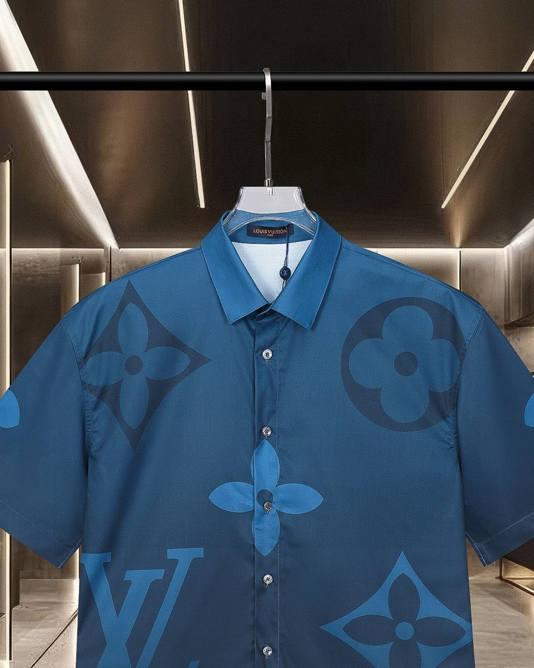 Bright blue short-sleeve shirt with pointed collar and tonal monogram-style print