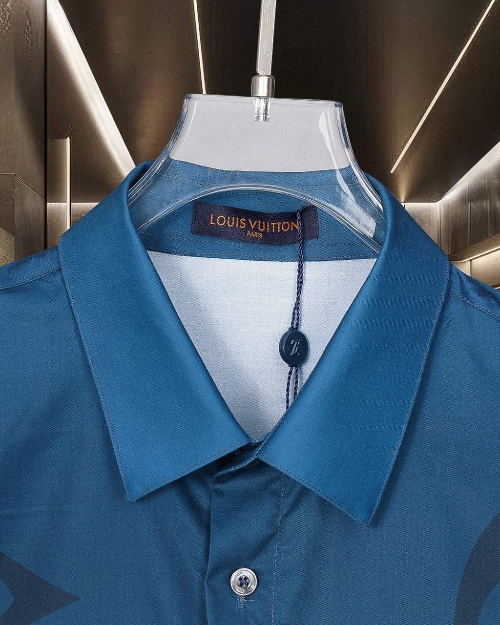 Bright blue short-sleeve shirt with button-front pointed collar and neck logo tag