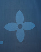 Bright blue short-sleeve shirt detail with flower-like tonal monogram motif