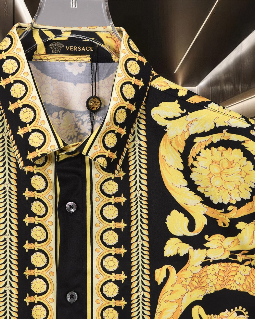 Versace short-sleeve shirt front close-up: black with gold baroque border and snap buttons