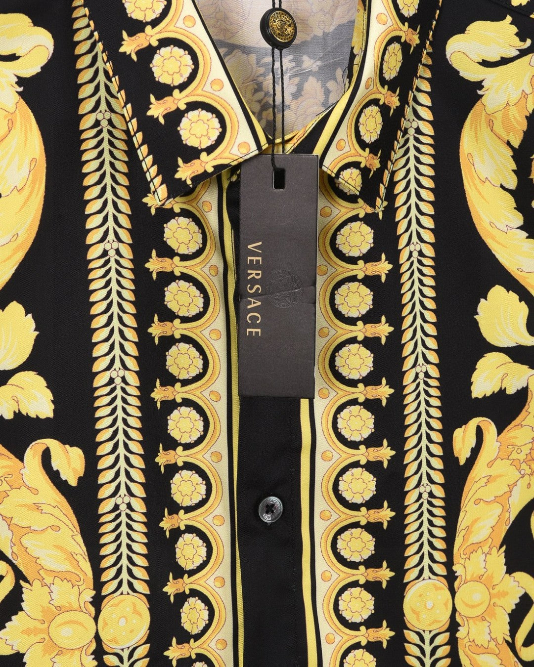 Versace short-sleeve shirt neckline close-up with gold baroque trim and logo button