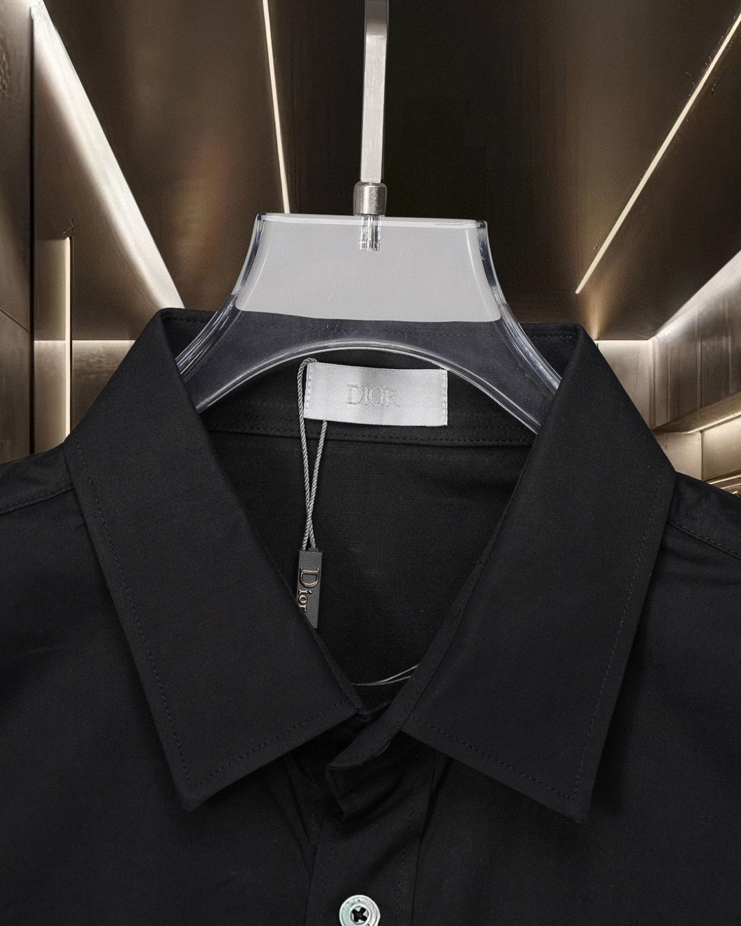 Black button-up shirt neckline with white interior label and button placket