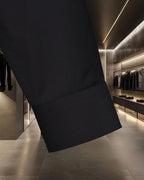 Black long-sleeve shirt with curved side hem and topstitching