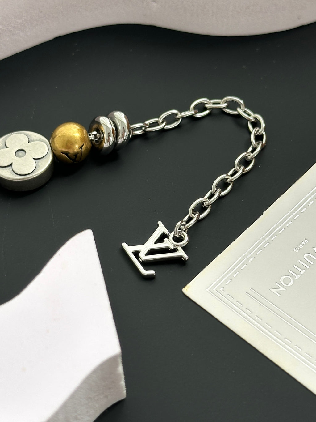 Silver chain bracelet with gold and silver beads and letter-shaped charm
