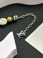 Silver chain bracelet with gold and silver beads and letter-shaped charm