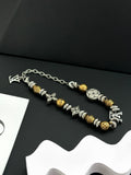 Silver and gold beaded charm bracelets with chain links on a dark background
