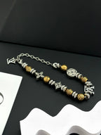 Silver and gold beaded charm bracelets with chain links on a dark background