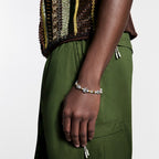 Person wearing a gold and silver beaded bracelet on the wrist