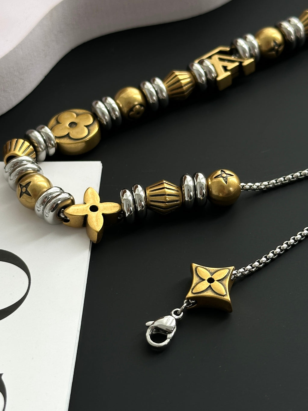 Louis Vuitton bead necklace close-up with gold and silver star pendant