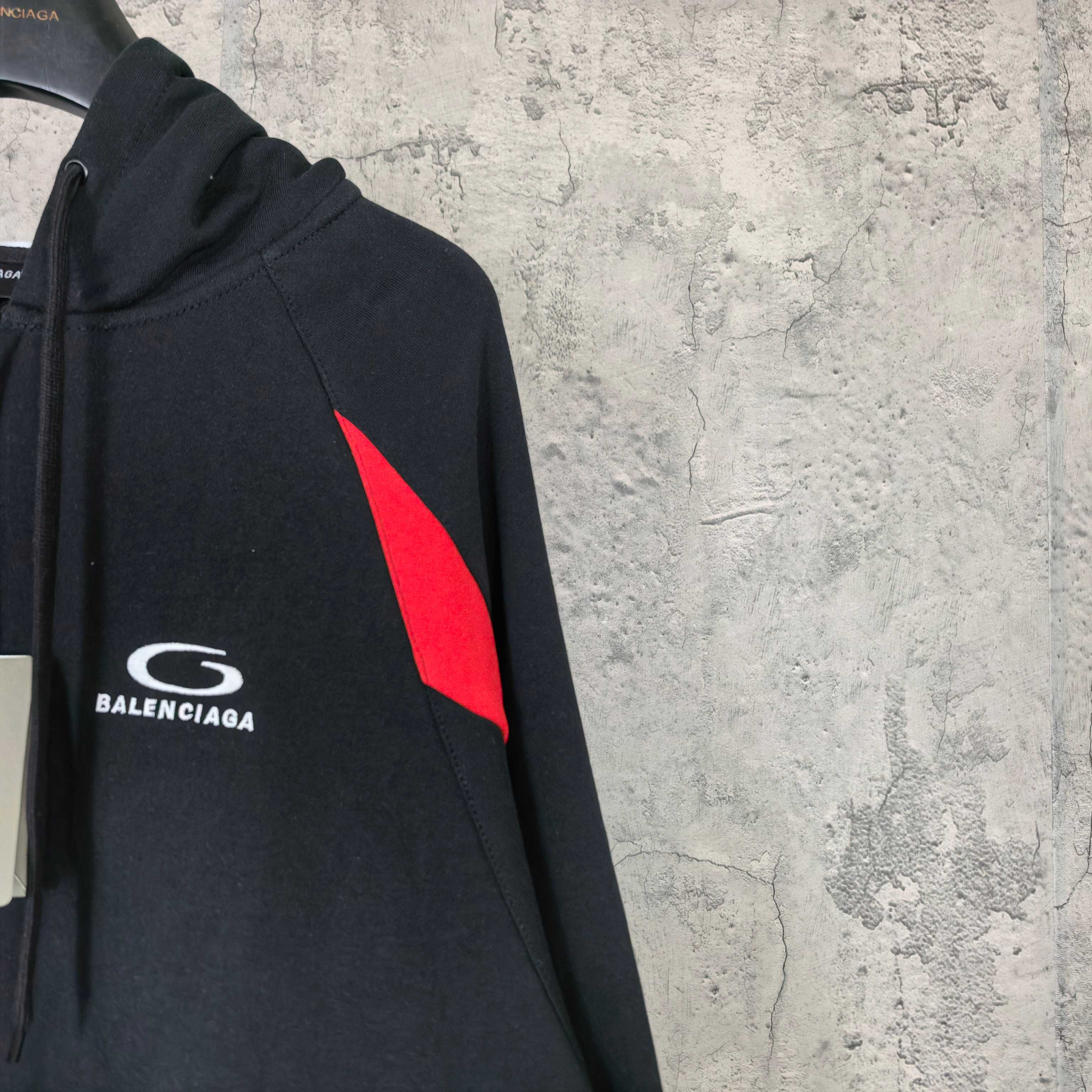 Balenciaga sleeve logo patch on black zip-up hoodie with red triangle