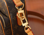 Monogram bag strap clasp with gold-tone hardware and tan leather edging