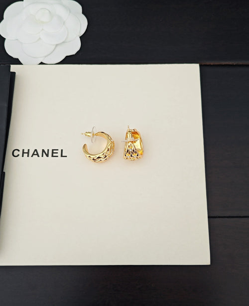 Gold-tone hoop and stud earrings with crystal-like details on white card
