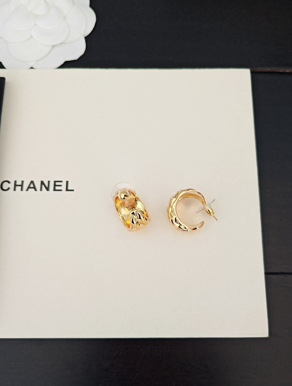 Gold-tone earrings, one hoop and one stud, with crystal-like details