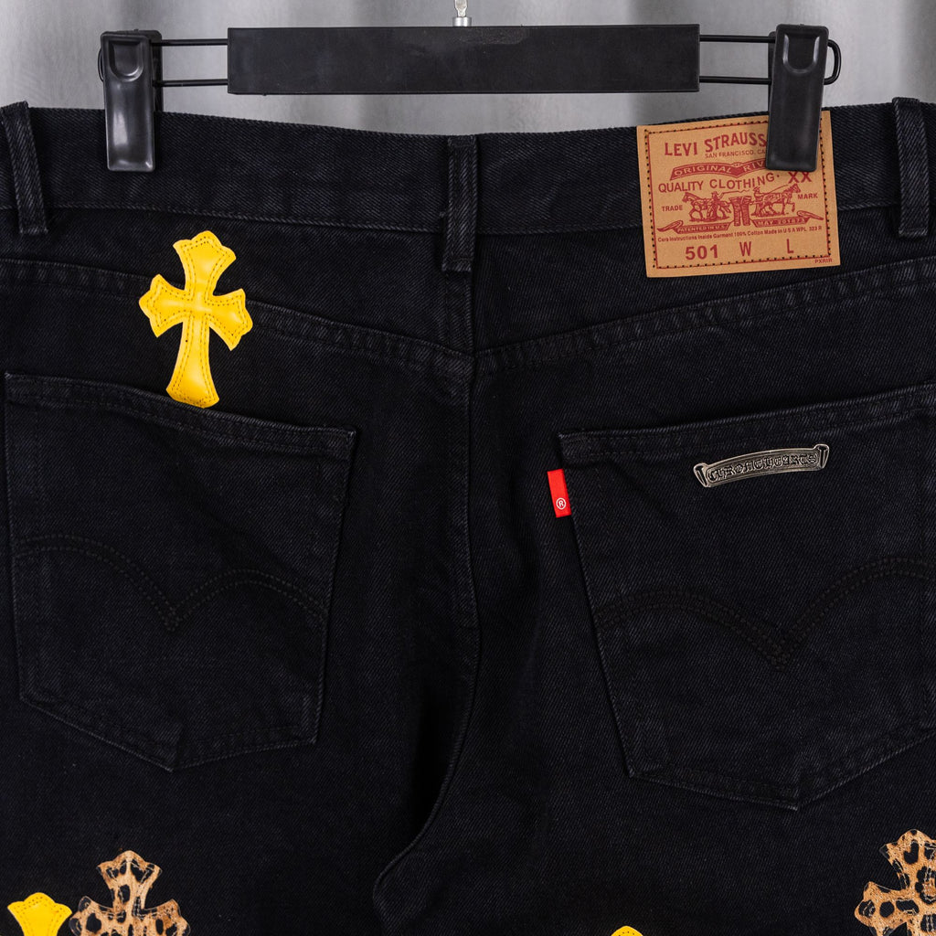 Black denim pants front view with yellow cross patches and Levi Strauss waistband label