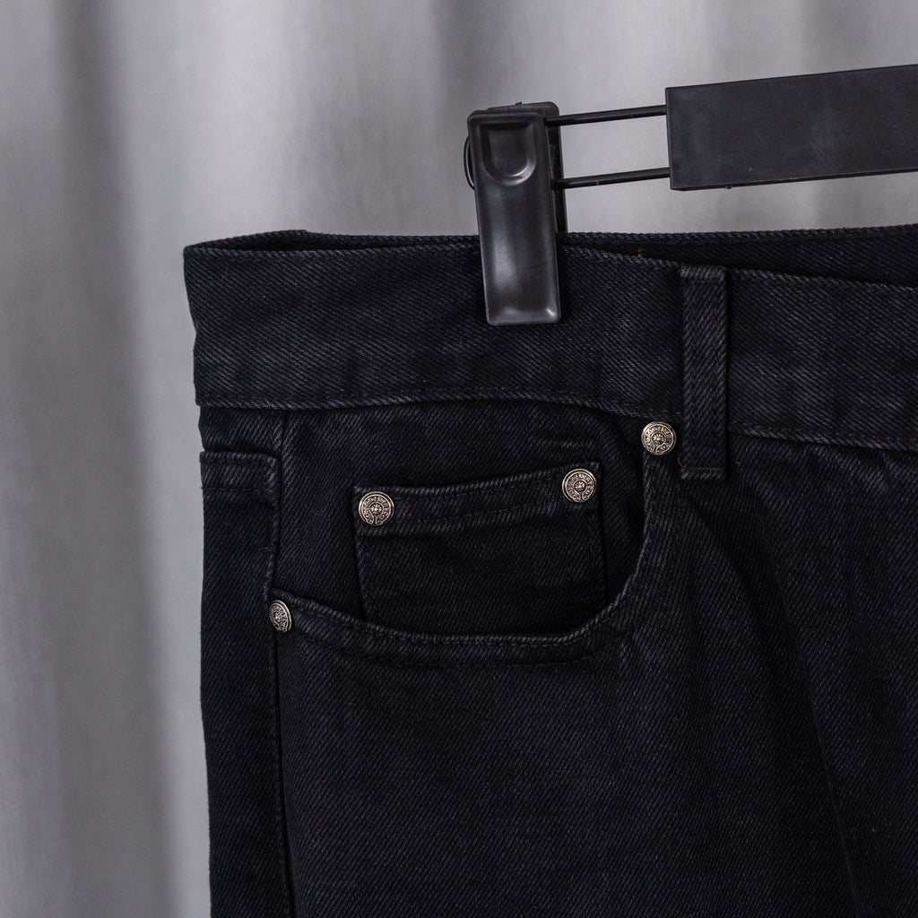 Black denim pants with buttoned front and pocket detailing.