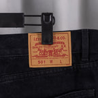 Black denim pants with Levi’s label at waistband and inner pocket seam.