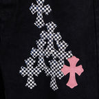 Black denim pants with large checkerboard cross graphic and pink cross emblem