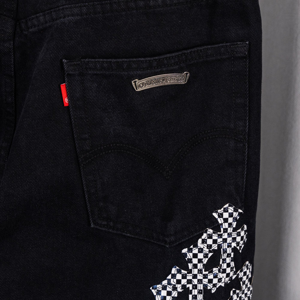 Black denim pants; logo patch and checkerboard cross graphic near front pocket