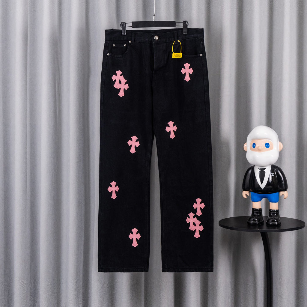 Dark denim pants with pink cross patches, button fly and belt loops.
