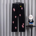 Dark denim pants with pink cross patches, button fly and belt loops.