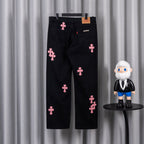 Dark denim pants with scattered pink cross embroidery, zip fly and front pockets.
