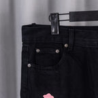 Dark denim jean pocket and waistband with metal rivets and belt loop detail.