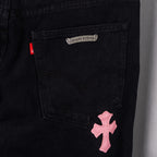 Black denim pants with pink cross patch on front pocket
