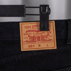 Levi Strauss label on black denim pants, size 501 W L tag on waistband.
