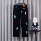 Black denim pants with blue and white cross appliques, front patch pockets.