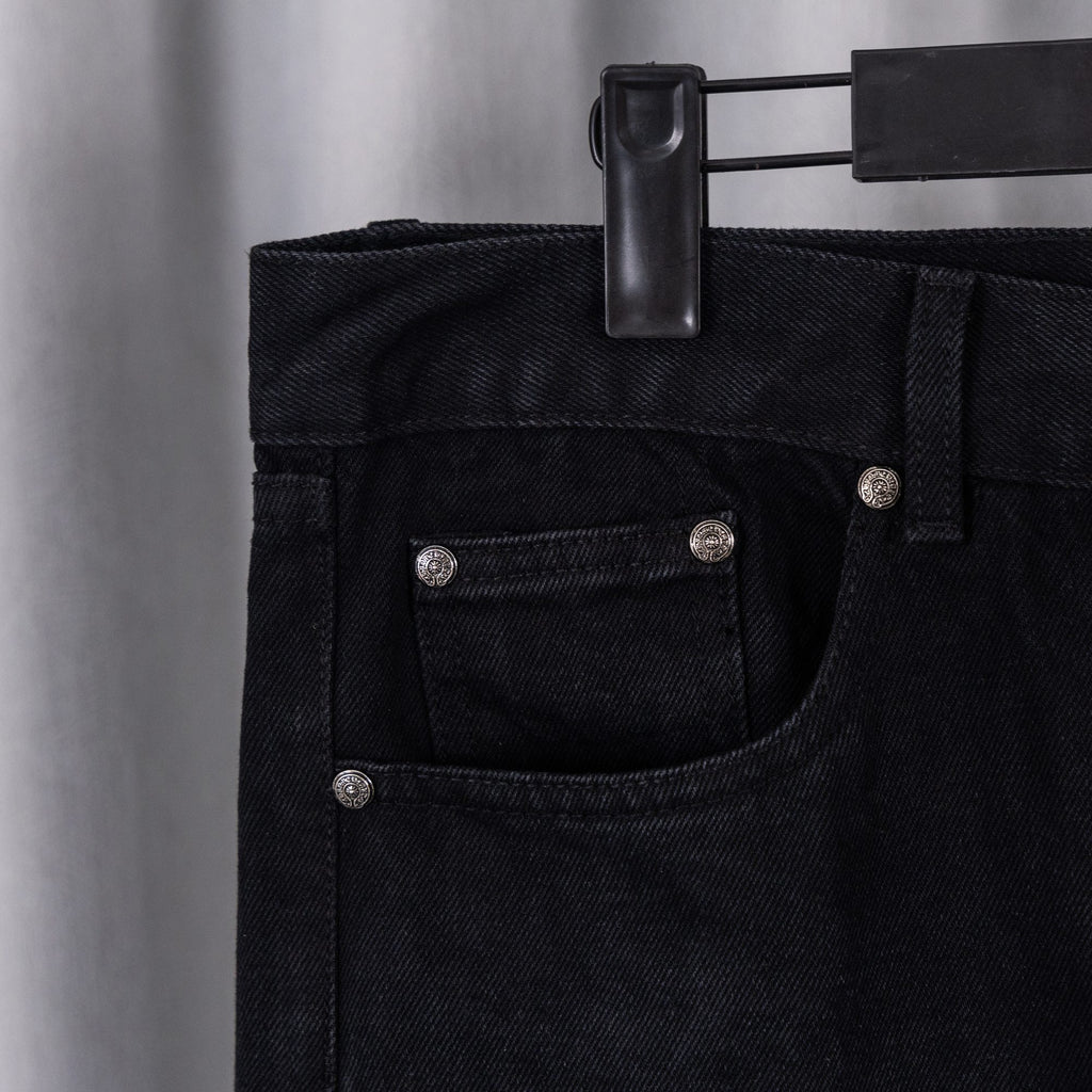 Black denim pants waistband with belt loops and buttoned front pocket.