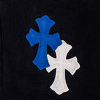 Blue and white cross appliques on black denim fabric.