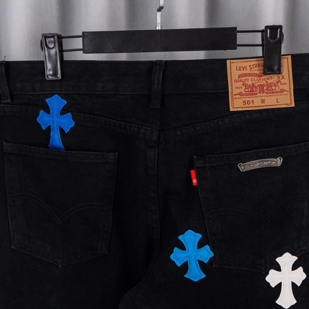 Black denim pants with Levi Strauss label and cross appliques on front.