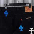 Black denim pants with Levi Strauss label and cross appliques on front.