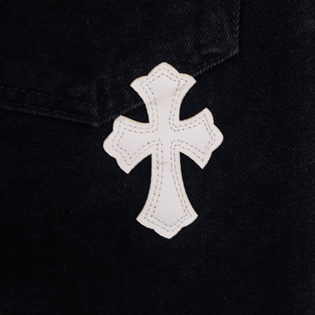 Black denim pants with white cross applique patch on pocket