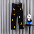 Black denim pants with yellow cross patches, button fly and belt loops