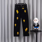 Black denim pants with yellow cross patches, button fly and belt loops
