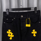 Black denim pants front with metal button, pockets, yellow cross patches, hang tag