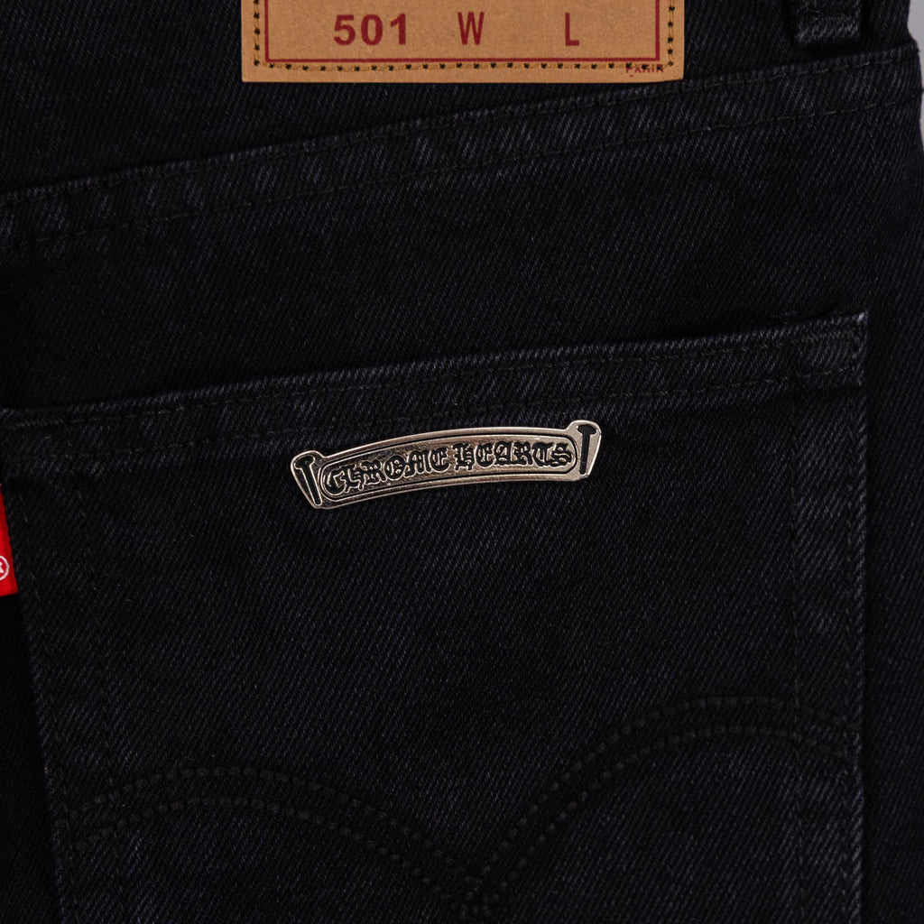 Silver logo label on black denim pocket