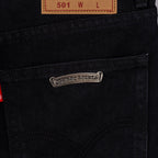 Silver logo label on black denim pocket