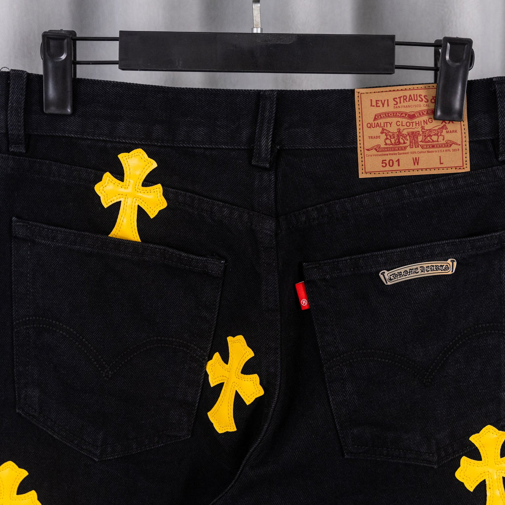 Black denim pants with Levi Strauss quality label and yellow cross patches