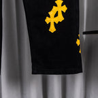 Black denim pant leg with yellow cross patch