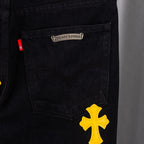 Black denim pants with yellow cross patch near front pocket