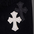 Black denim with a large white cross applique in stitched outline