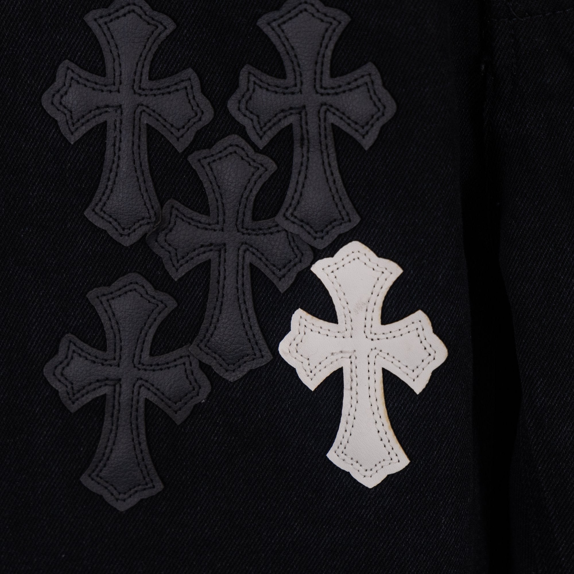 Black denim with multiple cross appliques, including one white cross