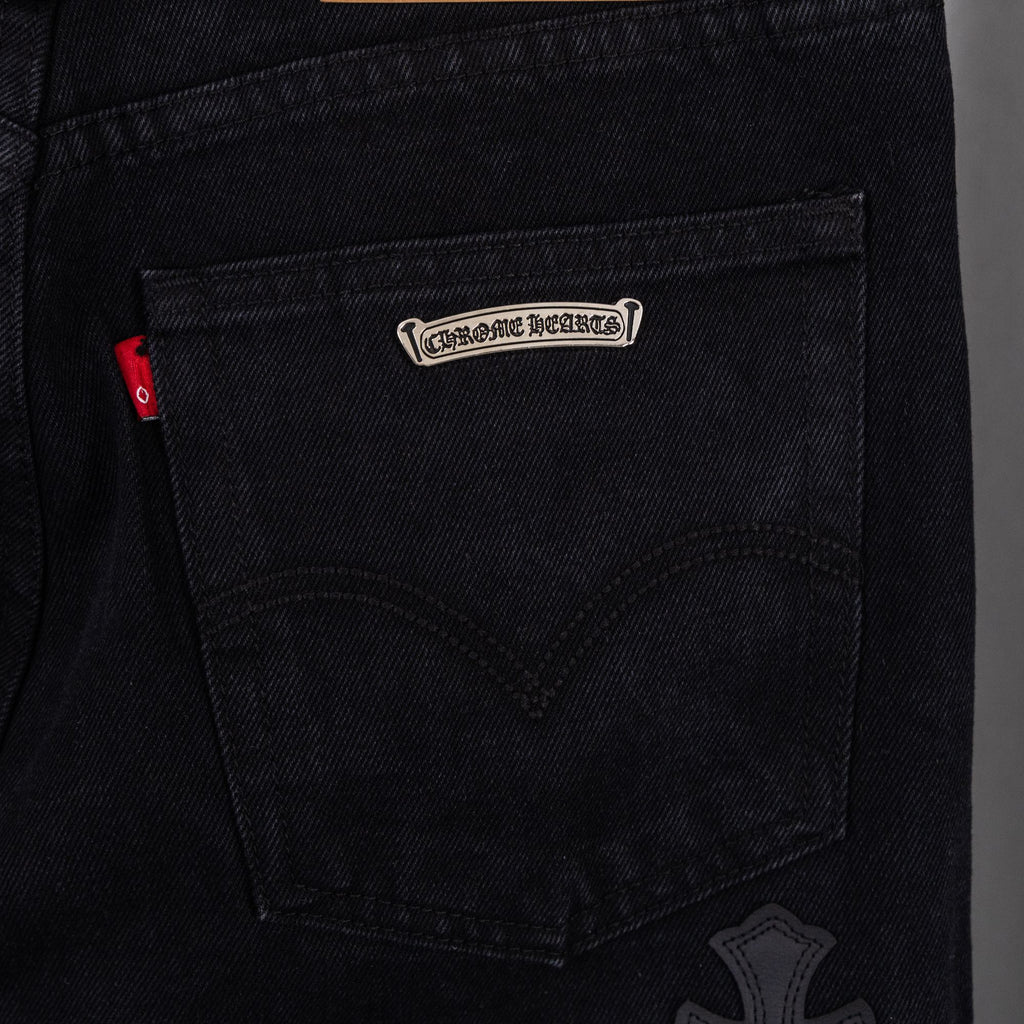 Black denim pants with logo patch on inner pocket and cross-stitch detail