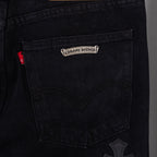 Black denim pants with logo patch on inner pocket and cross-stitch detail